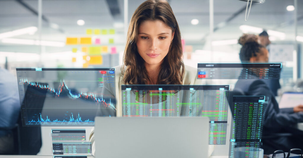 computer professional in front of computer screen analyzing statistics