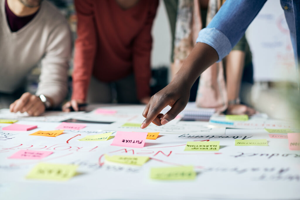 Close-up of black entrepreneur and his business team brainstorming while analyzing mind map on a meeting in the office.