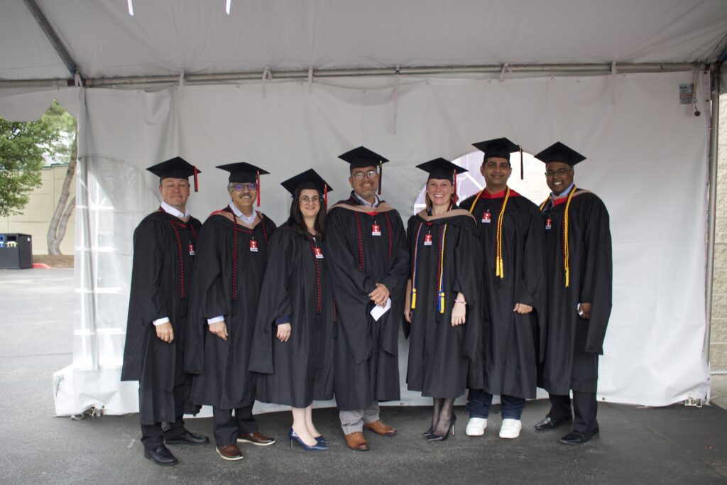 Group of Professional MBA students in their cap and gown regalia at the graduation ceremony
